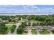 Expansive aerial view of a lakeside community featuring well-manicured lawns, mature trees, and a glimpse of the water at 2424 Plumadore Dr, Grand Island, FL 32735