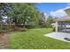 View of backyard features screened-in lanai, vinyl shed, and lush green lawn at 2424 Plumadore Dr, Grand Island, FL 32735