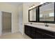 Bathroom featuring double sinks, dark cabinetry, and a door to the water closet at 2424 Plumadore Dr, Grand Island, FL 32735