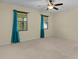 Comfortable bedroom with neutral carpet, ceiling fan, and two sunny windows at 2424 Plumadore Dr, Grand Island, FL 32735