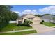Beautiful home featuring stucco facade, a two-car garage, manicured lawn, and lush landscaping at 2424 Plumadore Dr, Grand Island, FL 32735