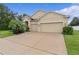 Charming home featuring stucco facade, three car garage, manicured lawn, and fresh landscaping at 2424 Plumadore Dr, Grand Island, FL 32735