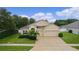 Beautiful home featuring stucco facade, a two-car garage, manicured lawn, and lush landscaping at 2424 Plumadore Dr, Grand Island, FL 32735