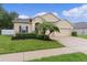 Beautiful home featuring stucco facade, a two-car garage, manicured lawn, and lush landscaping at 2424 Plumadore Dr, Grand Island, FL 32735