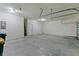 View of the spacious two car garage with white walls, a sealed floor, and an electric panel at 2424 Plumadore Dr, Grand Island, FL 32735