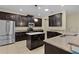 Modern kitchen features stainless steel appliances, dark wood cabinetry, and granite countertops at 2424 Plumadore Dr, Grand Island, FL 32735