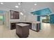 Bright kitchen with an island, granite countertops, stainless steel dishwasher, and dark wood cabinets at 2424 Plumadore Dr, Grand Island, FL 32735