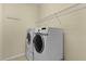 Laundry room with modern washer and dryer, featuring a shelf and light-colored paint at 2424 Plumadore Dr, Grand Island, FL 32735