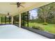 Screened porch with view of manicured backyard and two ceiling fans at 2424 Plumadore Dr, Grand Island, FL 32735