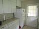 Bright kitchen with white cabinets, a refrigerator and access to the backyard at 2501 Sheridan Rd, Mount Dora, FL 32757
