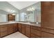 This spacious bathroom features dual sinks, a large mirror, and lots of cabinet storage at 2568 Jupiter Way, The Villages, FL 32163
