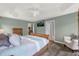 This spacious bedroom offers wood floors, a fan, a TV, and an armchair, creating a comfortable retreat at 2568 Jupiter Way, The Villages, FL 32163