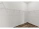 Walk-in closet features wood-look floors and shelving unit at 2568 Jupiter Way, The Villages, FL 32163