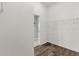 A view into a walk-in closet with wood-look floors and shelving unit at 2568 Jupiter Way, The Villages, FL 32163