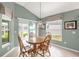 Sunlit dining area with wood table and chairs, vaulted ceilings, and sliding glass doors at 2568 Jupiter Way, The Villages, FL 32163