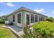 Exterior view of the home featuring an enclosed patio and manicured lawn at 2568 Jupiter Way, The Villages, FL 32163