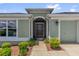 Inviting front entrance featuring an arched doorway with decorative security gate and stylish exterior lighting at 2568 Jupiter Way, The Villages, FL 32163