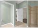 Hallway with neutral paint leads to a walk-in shower, bedrooms, and walk-in closet at 2568 Jupiter Way, The Villages, FL 32163