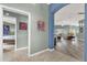 Hallway provides access to living area and a bedroom; decorative art and neutral walls at 2568 Jupiter Way, The Villages, FL 32163