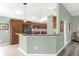 Open kitchen with bar seating features wood cabinets, stainless appliances, and pendant lighting at 2568 Jupiter Way, The Villages, FL 32163
