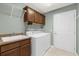 Laundry room features washer, dryer, sink, upper cabinets, and tile floors at 2568 Jupiter Way, The Villages, FL 32163