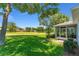 View of back of house with screened lanai overlooking a manicured lawn at 26822 Bull Run, Leesburg, FL 34748