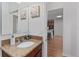 Bathroom featuring a vanity with granite countertop and decorative mirror, with view to kitchen at 26822 Bull Run, Leesburg, FL 34748