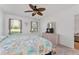 Brightly lit bedroom boasts a dresser with mirror and TV, and a colorful, patterned comforter at 26822 Bull Run, Leesburg, FL 34748