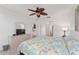 Brightly lit bedroom boasts a dresser with mirror and TV, and a colorful, patterned comforter at 26822 Bull Run, Leesburg, FL 34748