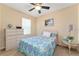 Bright bedroom features a ceiling fan, complemented by light walls, side table, and patterned bedding at 26822 Bull Run, Leesburg, FL 34748