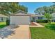 Well-maintained home boasts a pristine lawn, mature landscaping, and a spacious two-car garage at 26822 Bull Run, Leesburg, FL 34748