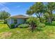 Rear of home with large yard, tropical landscaping, and screened in lanai at 26822 Bull Run, Leesburg, FL 34748