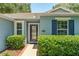 Close-up of the home's entrance, framed by manicured shrubs and charming shutters at 26822 Bull Run, Leesburg, FL 34748
