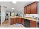 Well-lit kitchen with granite countertops, wooden cabinetry, and an open view to the living area at 26822 Bull Run, Leesburg, FL 34748