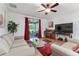 Cozy living room features a ceiling fan, hardwood floors, and sliding door access at 26822 Bull Run, Leesburg, FL 34748