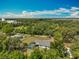 Expansive aerial view of home with pool, surrounded by lush greenery and blue skies at 27610 Debbie Rd, Okahumpka, FL 34762