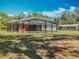 Expansive backyard with a screened pool and lush landscaping offering privacy at 27610 Debbie Rd, Okahumpka, FL 34762