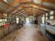 Large barn with a wooden floor and metal walls is filled with natural light at 27610 Debbie Rd, Okahumpka, FL 34762