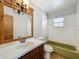 Traditional bathroom with an oversized mirror, white tiled shower, and green bathtub at 27610 Debbie Rd, Okahumpka, FL 34762