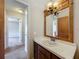 Charming bathroom with a white sink and custom mirror frame next to the bedroom at 27610 Debbie Rd, Okahumpka, FL 34762
