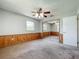 Bedroom with paneling, mirrored closet, ceiling fan, carpeted floors, and natural light at 27610 Debbie Rd, Okahumpka, FL 34762
