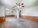 Bedroom with mirrored closet doors, paneling, carpeted floors, and natural light at 27610 Debbie Rd, Okahumpka, FL 34762