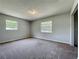 Spacious bedroom featuring neutral walls, plush carpeting, and two windows for natural light at 27610 Debbie Rd, Okahumpka, FL 34762