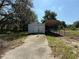 A barn-style garage and car port, set against a backdrop of trees, creating a rustic appeal at 27610 Debbie Rd, Okahumpka, FL 34762