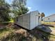 Exterior view of a white barn-style garage showcasing its structure and surrounding landscape at 27610 Debbie Rd, Okahumpka, FL 34762