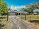 Charming brick home with a well-maintained lawn, gated driveway, and a two-car garage at 27610 Debbie Rd, Okahumpka, FL 34762