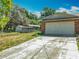 Exterior view of a two car garage, with a large driveway and additional carport in the back at 27610 Debbie Rd, Okahumpka, FL 34762