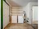 Functional laundry area equipped with a washing machine, dryer, shelving, and a water heater at 27610 Debbie Rd, Okahumpka, FL 34762