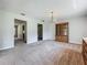 Open living area with chandelier and carpet, showcasing seamless flow and elegant lighting at 27610 Debbie Rd, Okahumpka, FL 34762