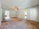 A spacious living room with neutral walls, carpet flooring, and a ceiling fan at 27610 Debbie Rd, Okahumpka, FL 34762
